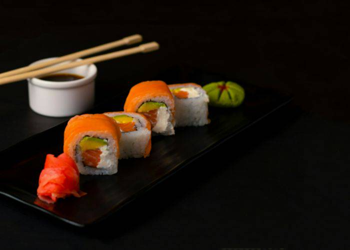 Fancy sushi served on a black serving tray, showing a selection of seafood sushi.